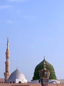 A serene photo showcasing the domes and minaret of Masjid An-Nabawi in Madinah, Saudi Arabia
